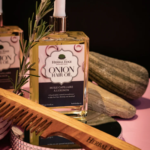 Herbal Edge Onion Hair Oil bottle with a comb and onion on a dark background