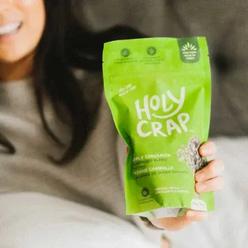 Person holding a green 'Holy Crap' grain blend package