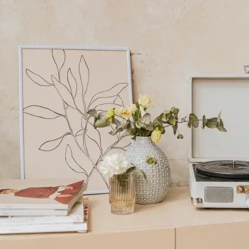 Minimalist home decor with modern art print, fresh flowers, and vintage record player