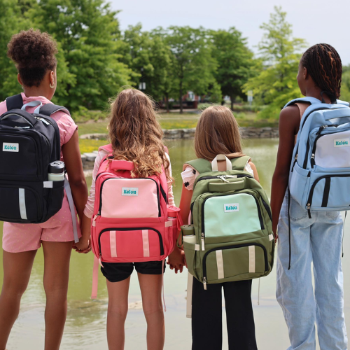 Four children wearing Kelou brand backpacks with a park in the background