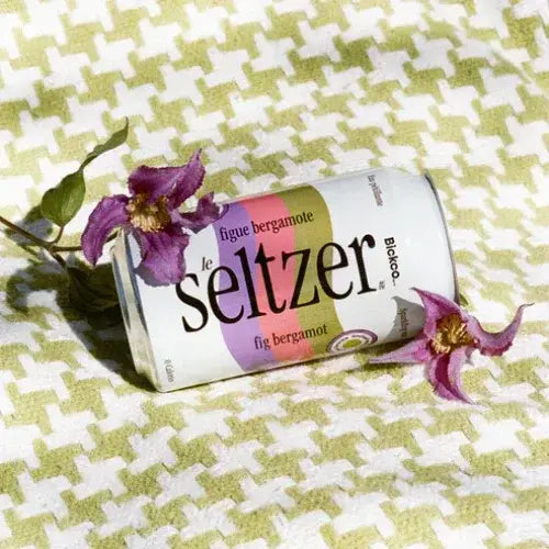 Le Seltzer can with flowers on a patterned fabric background