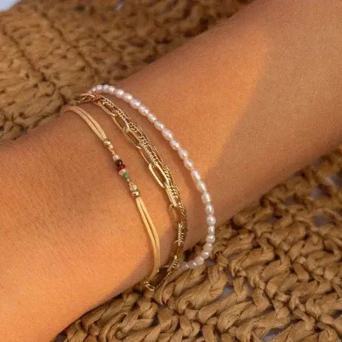 Stacked bracelets with pearls, gold chain, and colourful beads on a wrist – Delicate, handcrafted jewellery by Canadian designer Leah Alexandra
