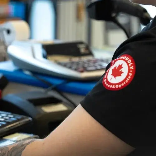 Person wearing a black shirt with a red and white logo in an office setting