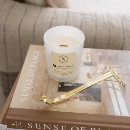 Candle on a book with a gold tool on a textured surface