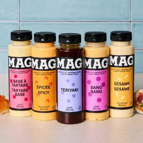 Five bottles of Mag sauce with colourful labels on a kitchen counter.