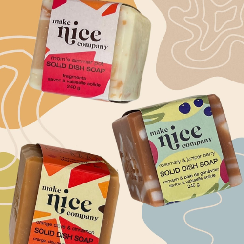 Three bars of 'make nice company' solid dish soap on a colourful abstract background
