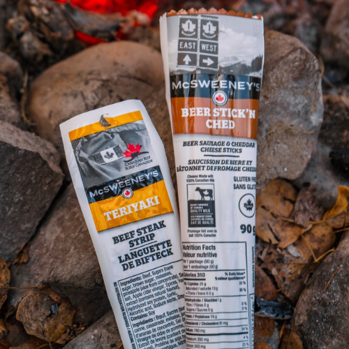 Two packages of McSweeney's food products on a rocky surface