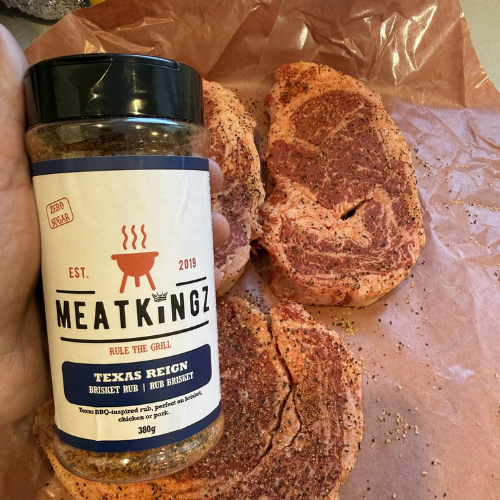 Meat seasoning jar labeled 'MEATKINGZ' with seasoned steaks on brown paper