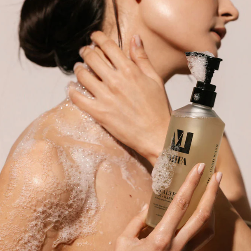 Person applying a foamy product to their shoulder with a bottle labeled 'Mifa'.