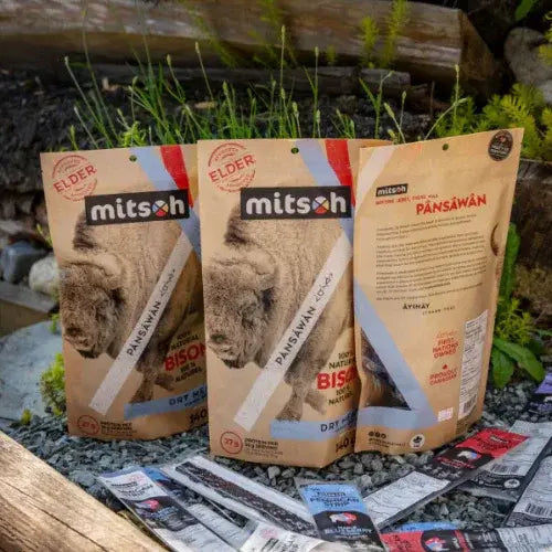Three packages of Mitsoh branded food products on a natural background with grass and rocks.