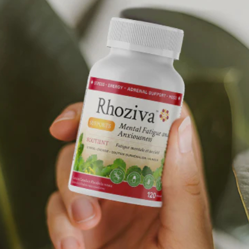 Hand holding a bottle of Rhoziva supplements with a blurred background