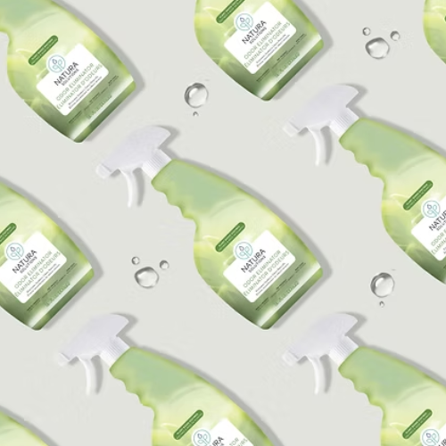 Multiple green spray bottles with white nozzles on a light gray background