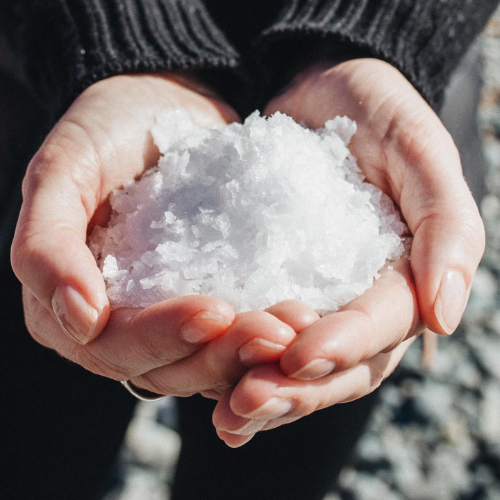 Hands holding a small pile of salt