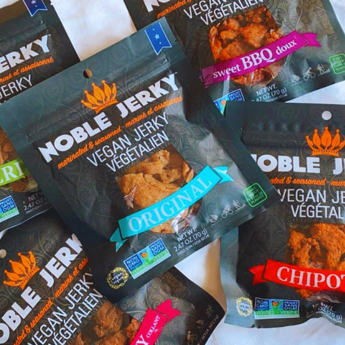 Multiple packages of Noble Jerky with different flavors on a white surface