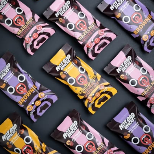 Assorted packages of Not Bad Snacks on a dark background