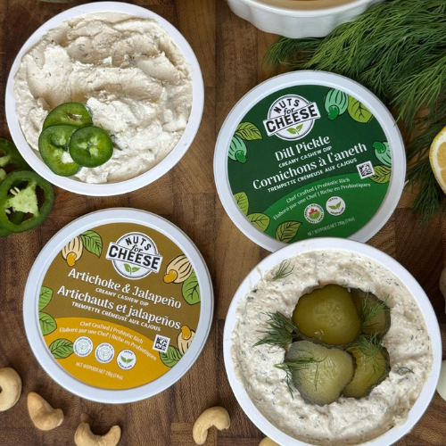 Nuts for Cheese with dill pickle and artichoke jalapeno flavors on a wooden board.