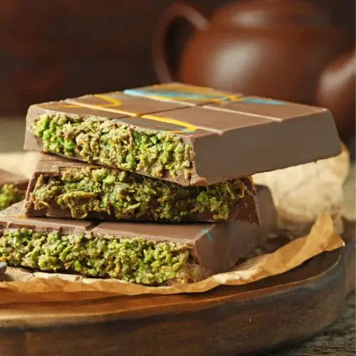 Chocolate bar with green filling on a wooden surface