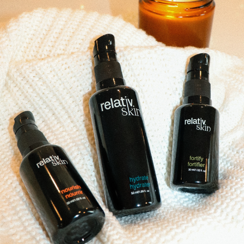 Three black 'relativ skin' bottles on a textured white surface
