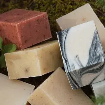 Assorted bars of soap with different colors and textures on a natural background