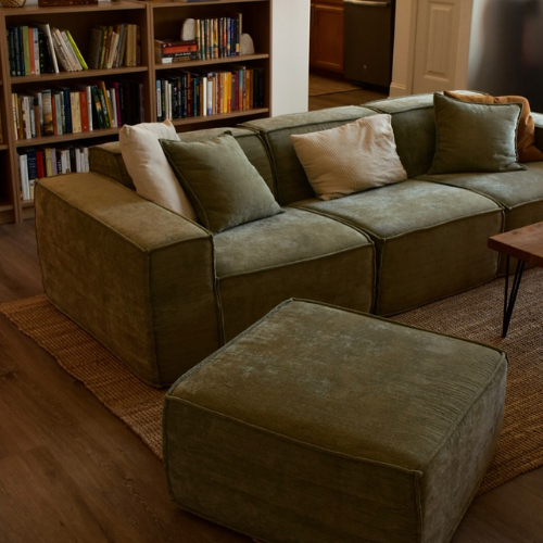 Green sectional sofa with ottoman in a living room setting