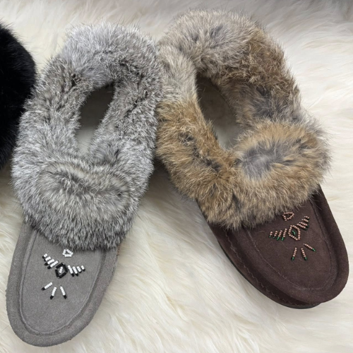 Pair of gray and brown fuzzy slippers on a white fluffy surface