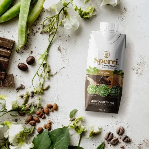 Sperri chocolate shake packaging on a rustic surface with green beans, flowers, and coffee beans.