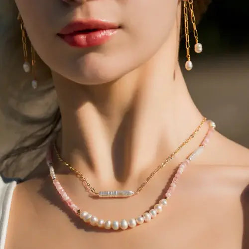 Close-up of a woman wearing a pearl necklace and earrings with a blurred background