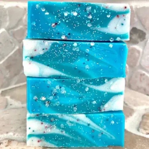 Stack of blue and white speckled soap bars on a textured surface