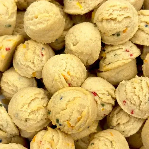 Close-up of a pile of round, beige cookies with colorful specks