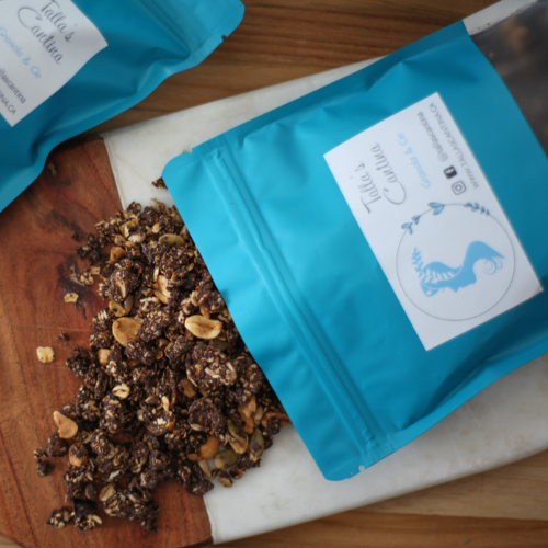 Open teal tea packaging with visible tea leaves on a wooden surface