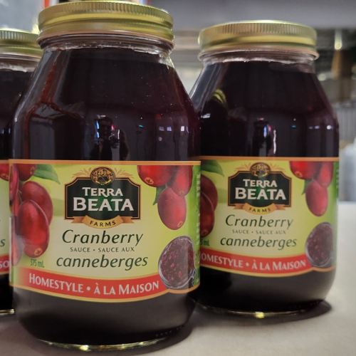 Two jars of Terra Beata cranberry sauce on a reflective surface