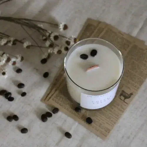 Candle with coffee beans on a newspaper background