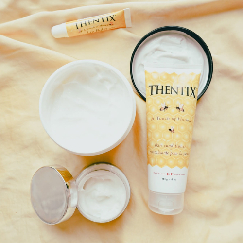 Thentix skincare products on a beige fabric background