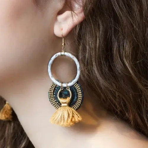 Close-up of a woman wearing a decorative earring with tassels.