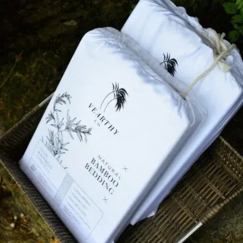 White bamboo bedding with 'Vearthy' branding in a woven basket on a natural background