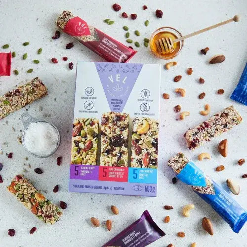 VEL granola bars with packaging on a light surface with nuts and honey.