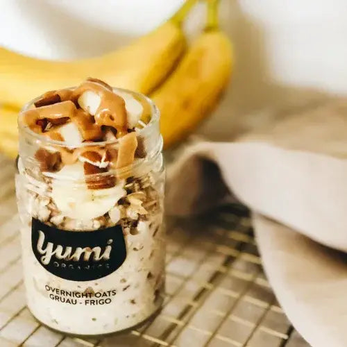 Jar of Yumi overnight oats with bananas in the background