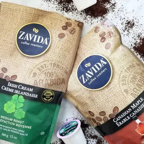 Two Zavida coffee packages with coffee beans and a coffee filter on a white background.